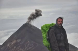 hiker On the summit of Acatenango with Volcán del Fuego in the background