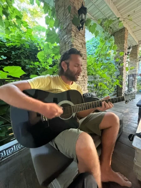 guy playing guitar in Wanderlust Boutique Hostel in almaty