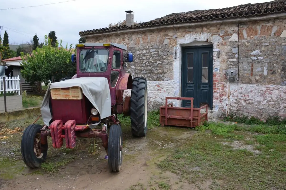 Rustic imagery of old stone house and tractor in asminio village on north evia