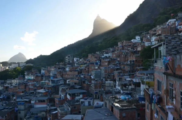 Pôr do sol atrás do Cristo Redentor visto da Favela Santa Marta