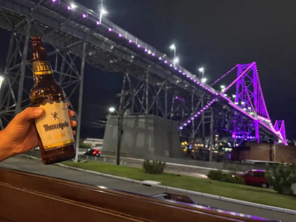 having a therezopolis brazilian beer under the purple lit bridge of  Hercílio Luz 
