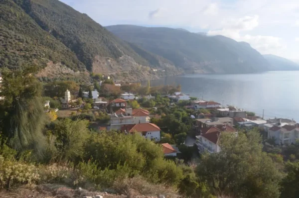 Coastal view of Ilia village with red-roof houses and calm sea along northern Evia, Greece