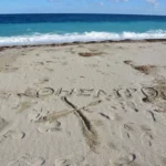 an X and θησαυρός (Greek for treasure) carved in sand at korasida beach on east evia island