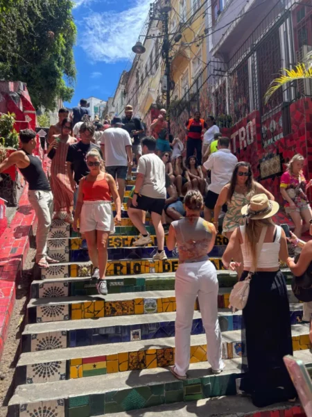Crowds of visitors climb the famous Escadaria Selarón in Lapa, Rio de Janeiro, a vibrant staircase mosaic of colorful tiles from around the world, created by artist Jorge Selarón and now a major cultural attraction.