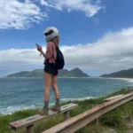 girl wearing a helmet Enjoying a panoramic view of Armação Beach in florianopolis during a bike ride break