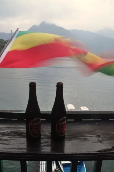 Man reading in a hammock on a terrace overlooking Lake Atitlán and the surrounding hills