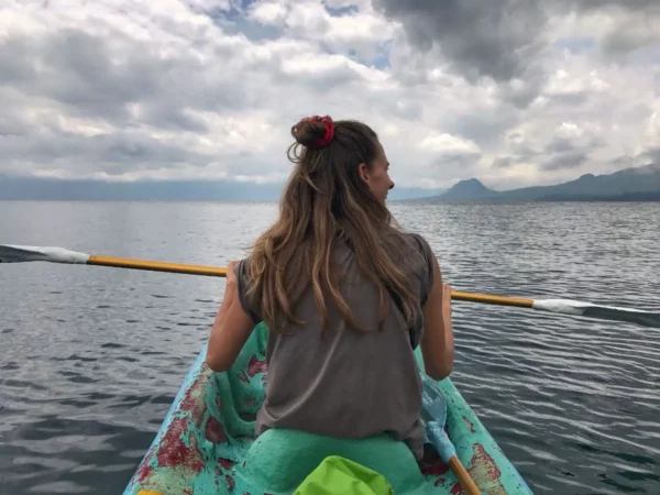 kayaking in lake atitlan under a cloudy sky