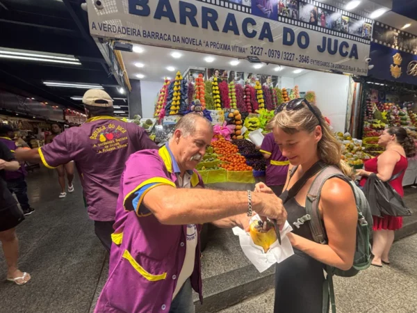 Dude force-feeding tourist in sao paulo market before attempting to scam