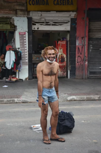 Usuário de crack sem camisa sorrindo para a câmera na Cracolândia