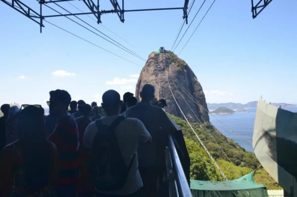 Turistas esperando em meio à multidão para embarcar no bondinho do Morro da Urca ao Pão de Açúcar