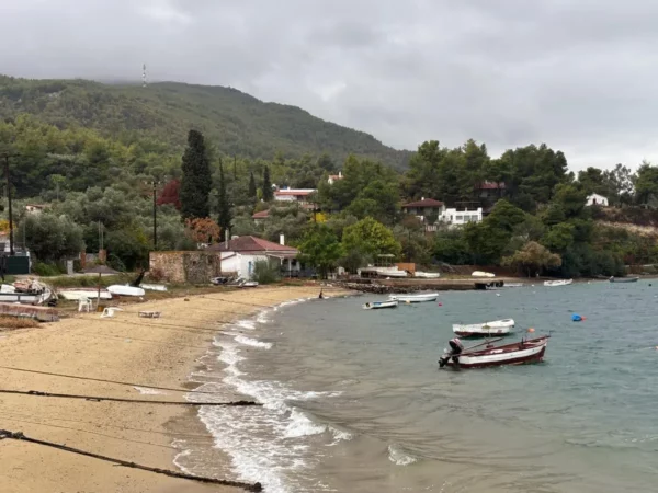 Small fishing boats anchored by a sandy beach in gialtra village, northern Evia, Greece