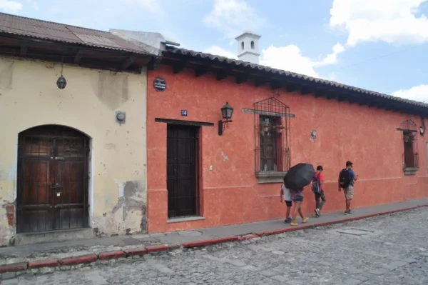 Colorful colonial street in southern Antigua Guatemala with traditional houses and pedestrians.