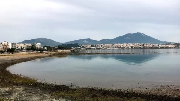 Serene coastal view at Chalkis, Euboea, Greece, featuring calm waters, distant mountains, and a peaceful shore.