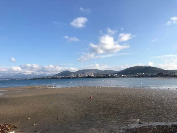 Serene coastal view in Chalkis, Euboea, Greece, featuring mountains in the background and a clear blue sky.