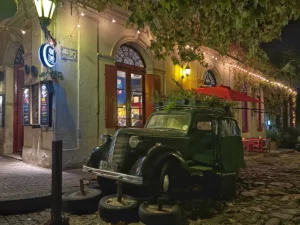 Antique car turned planter/tourist magnet outside of vintage restaurant in central Colonia del sacramento