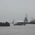 The ferry at the port of Colonia behind a rusted sunken ship in the fog