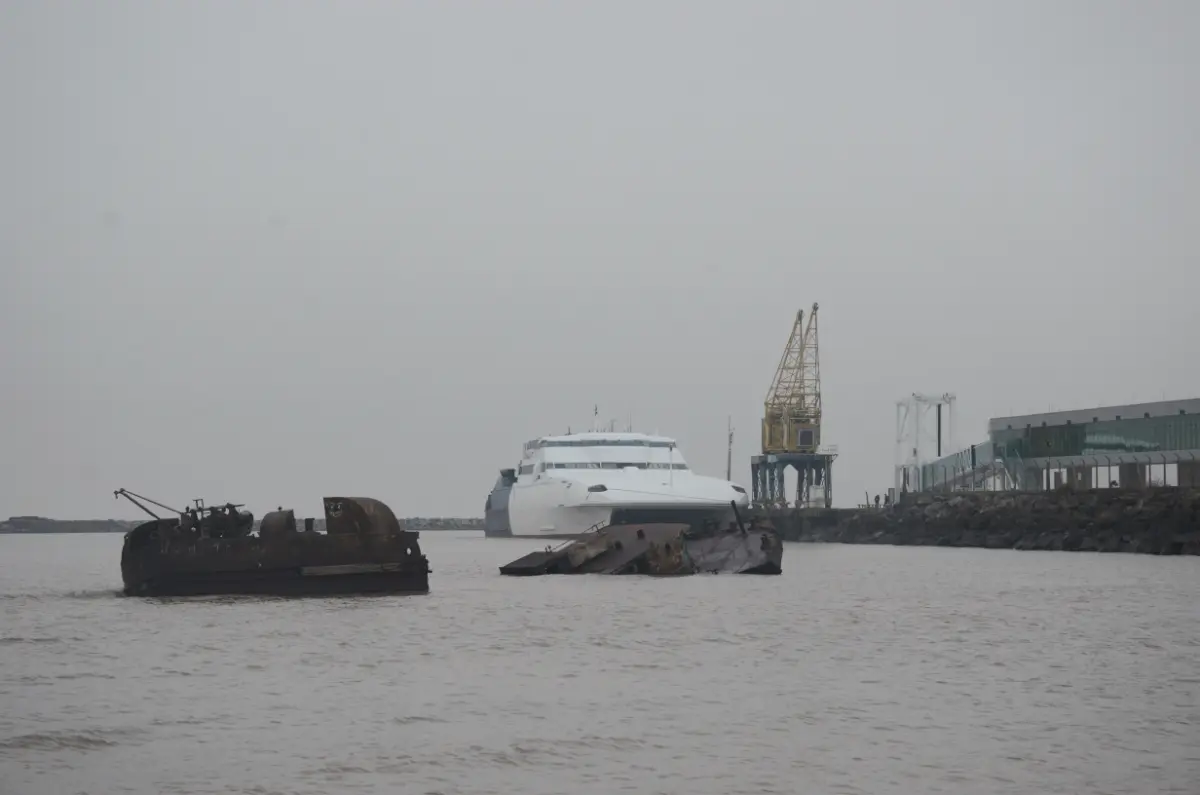 The ferry at the port of Colonia behind a rusted sunken ship in the fog