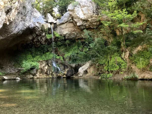 Drymonas Waterfall flowing into a clear natural pool near Mantoudi, Evia, Greece.