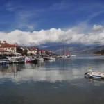 Harbor of Galaxidi with small boats moored along the waterfront and neoclassical houses climbing the hillside above the Corinthian Gulf.