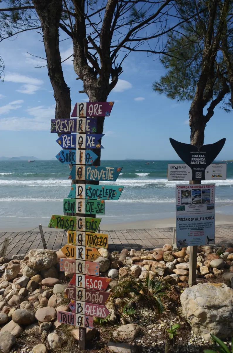 Letreiro pintado à mão com palavras positivas em acróstico com "PRAIA DE GAROPABA"