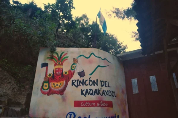 Colorful mural of local culture at Rincón del K'ajak'axol near Lake Atitlán, Guatemala, with vibrant colors and a flag in the background.