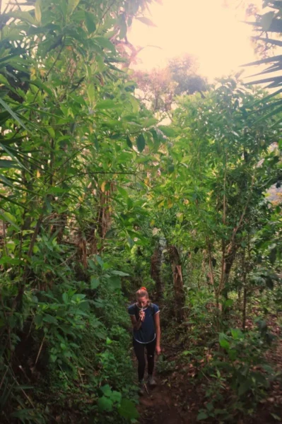 girl hiking in the jungle along trail to indian nose at lake atitlan in guatemala