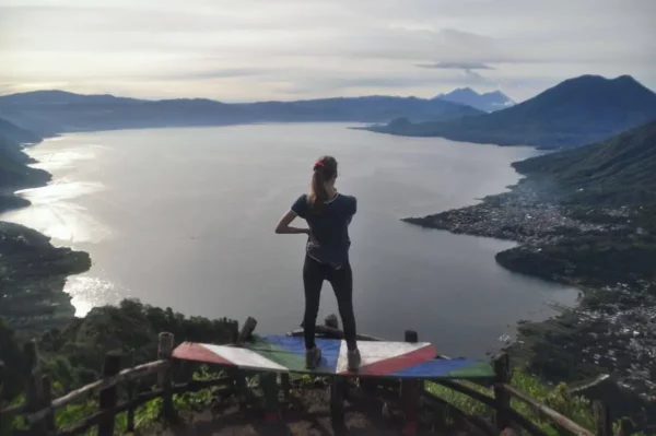 girl staring at the entirety of Lake Atitlán from the Indian Nose during sunrise