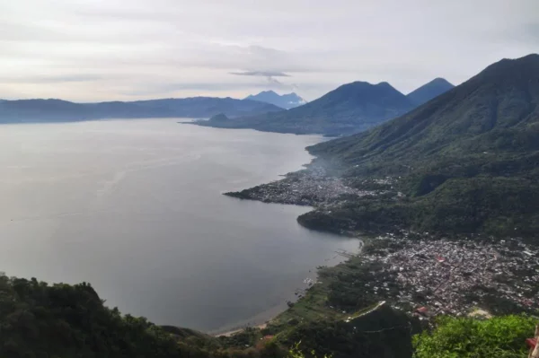 Breathtaking view of Lake Atitlán from Indian Nose, showcasing tranquil waters and surrounding mountains under a cloudy sky.