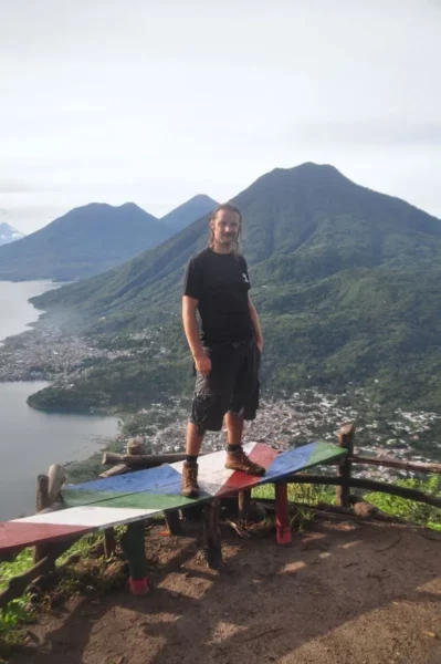 Indian Nose offers a stunning view of Lake Atitlán, with lush green mountains and a sky filled with soft clouds.
