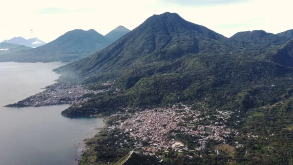 Aerial view of Lake Atitlán, showcasing the lush mountains and vibrant town nestled along the shoreline, Guatemala.