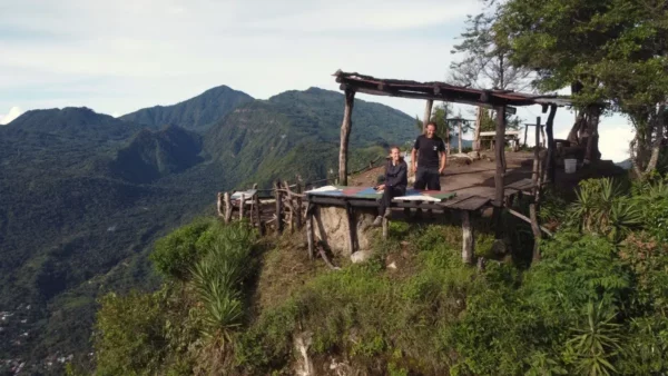 Indian Nose overlooking Lake Atitlán, Guatemala, features a wooden viewpoint with people admiring the stunning mountain scenery.
