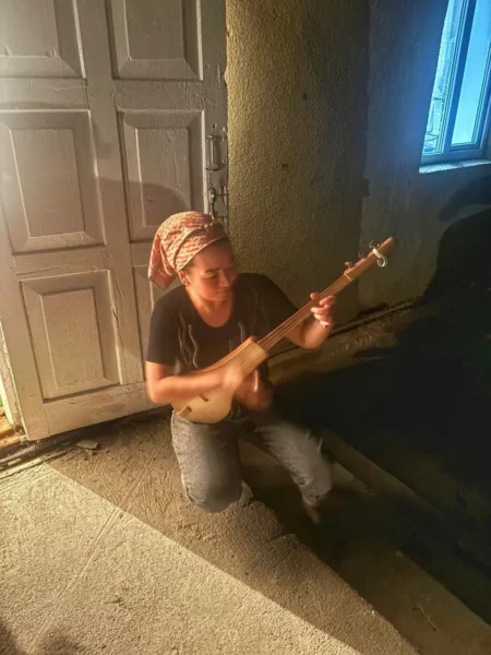 kyrgyz woman playing the komuz traditional string instrument