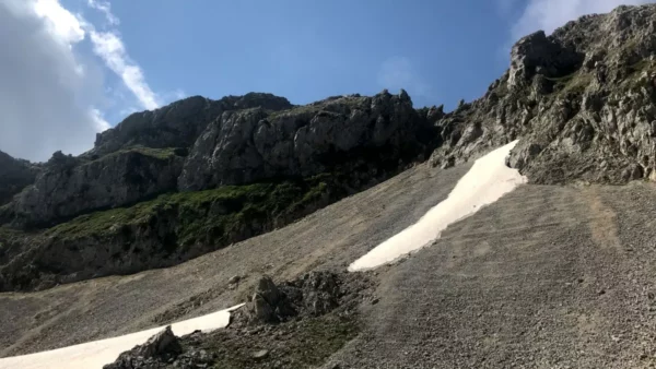 Snow patches and rocky terrain contrast against the blue sky on Mount Xerovouni, Euboea, Greece.