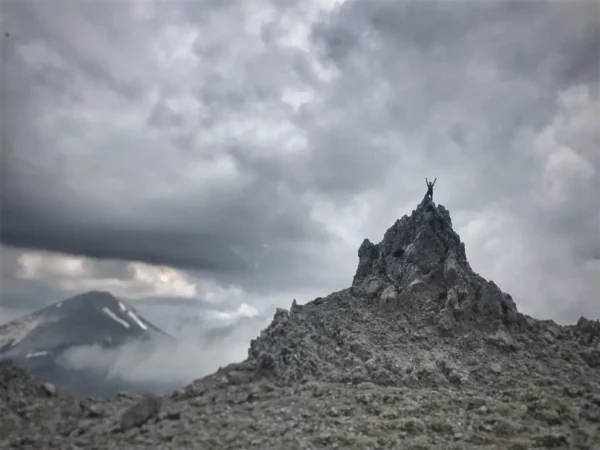 Dramatic rocky peak of Mount Xerovouni rising against a moody sky on Euboea, Greece, showcasing rugged terrain and distant mountains.