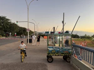 popcorn cart and kid cycling at the guiaba riverside promenade of porto alegre