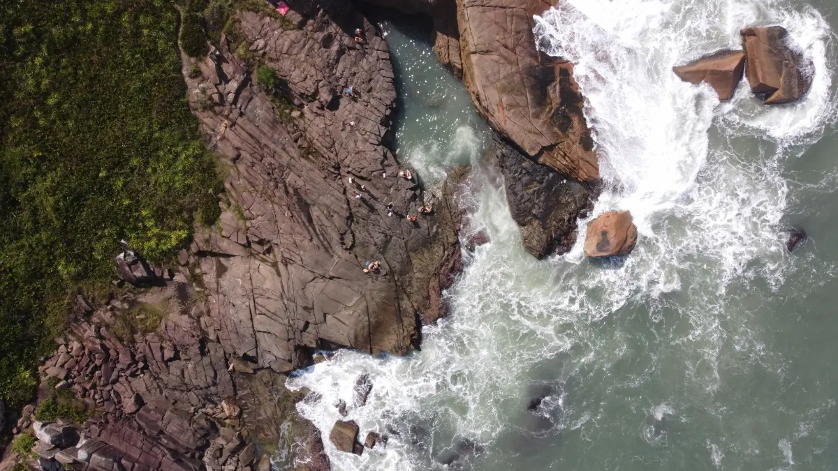 vista aérea dos penhascos batidos por ondas entre a Praia do Rosa e a Praia Vermelha