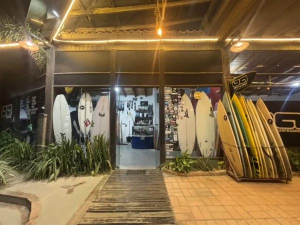 Surfboards displayed outside a shop at Praia do Rosa in Santa Catarina, Brazil, with vibrant colors and warm lighting.