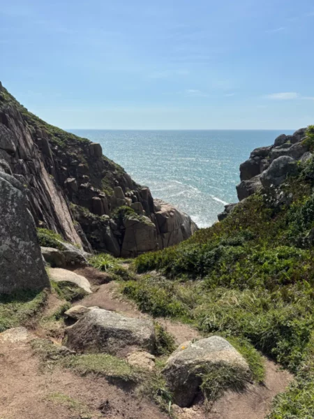 Scenic view of rugged cliffs and vibrant greenery overlooking the ocean at Praia do Rosa, Santa Catarina, Brazil.