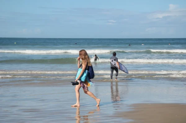 girl walking on shore of praia do rosa in beach in brazil