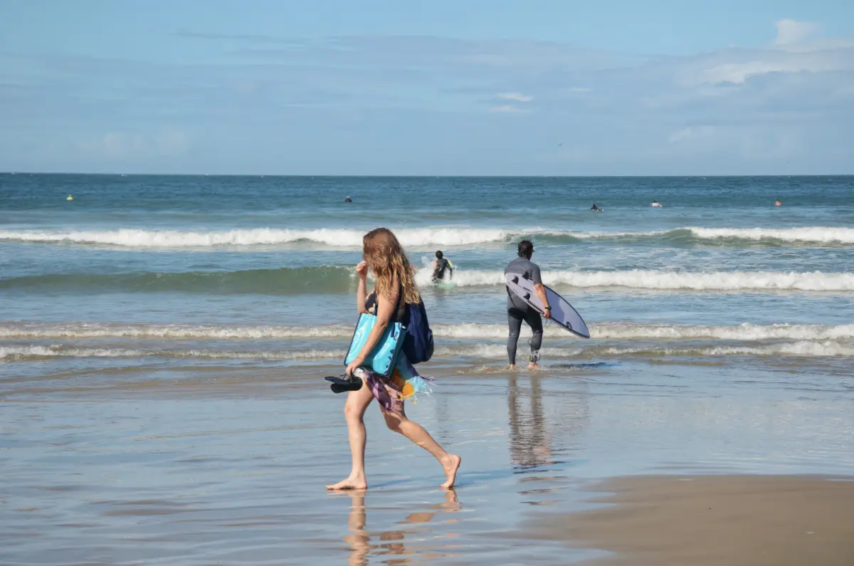 girl walking on shore of praia do rosa in beach in brazil