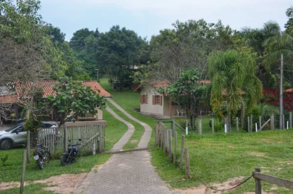 Charming path leading to cozy lodges surrounded by lush greenery in Praia do Rosa, Santa Catarina, Brazil.
