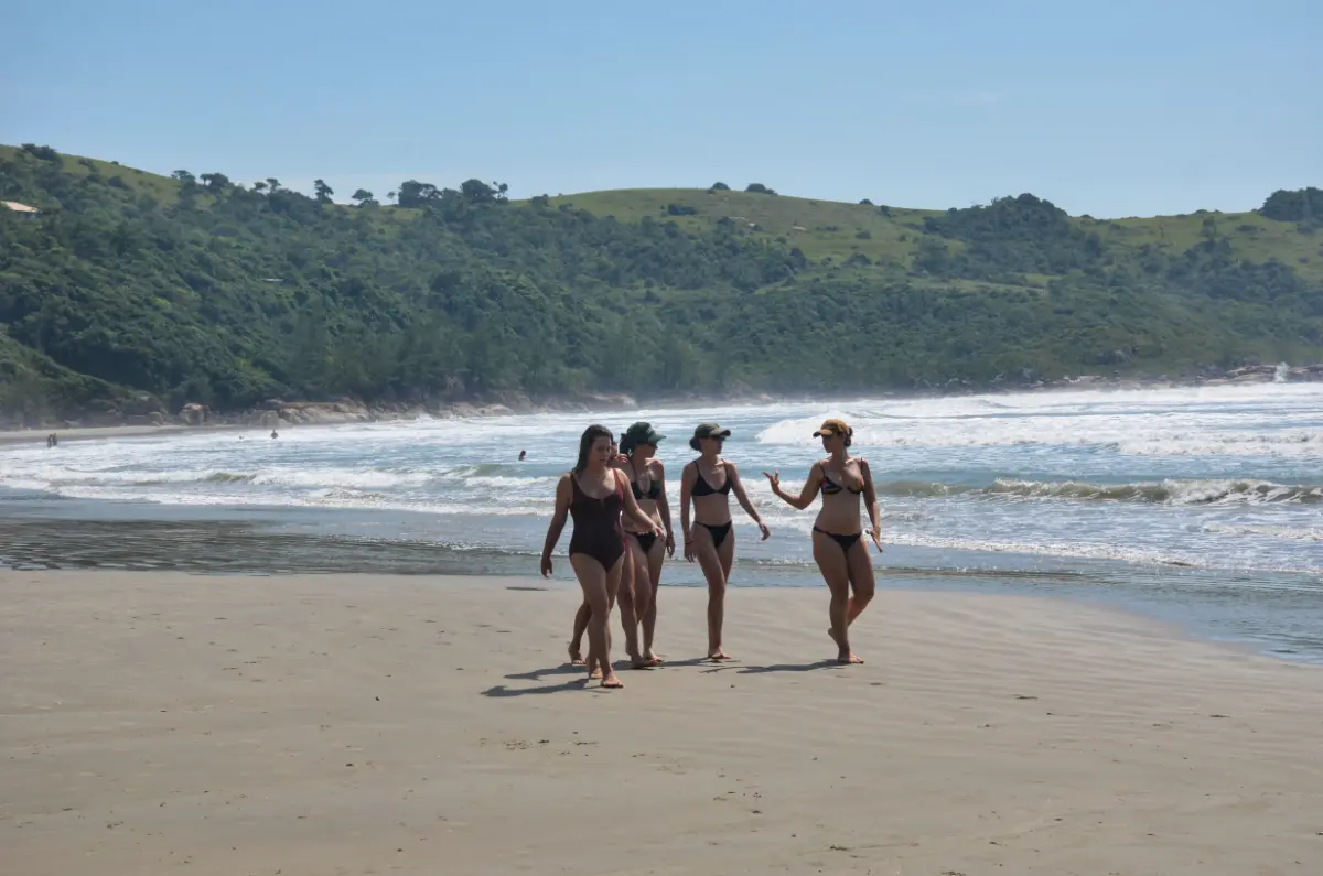 brazilian girls walking on sand at praia vermelha near praia do rosa in santa catarina