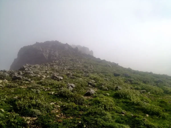Misty landscape of Xerovouni with rocky terrain and lush greenery, creating a serene and tranquil atmosphere.