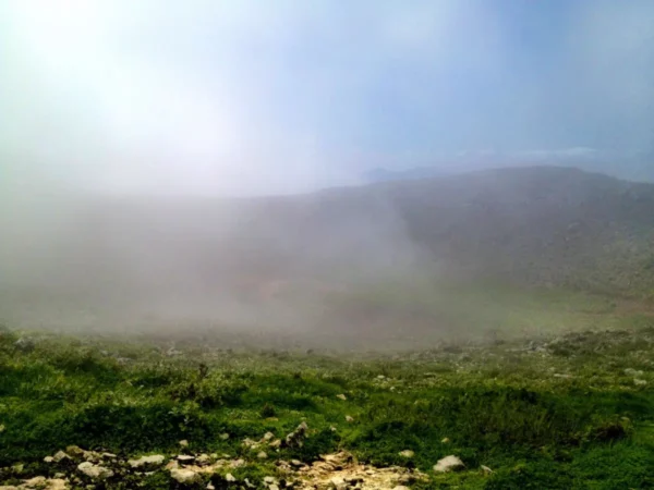 Misty landscape with lush greenery and rocky terrain at Xerovouni, creating an enchanting natural atmosphere.