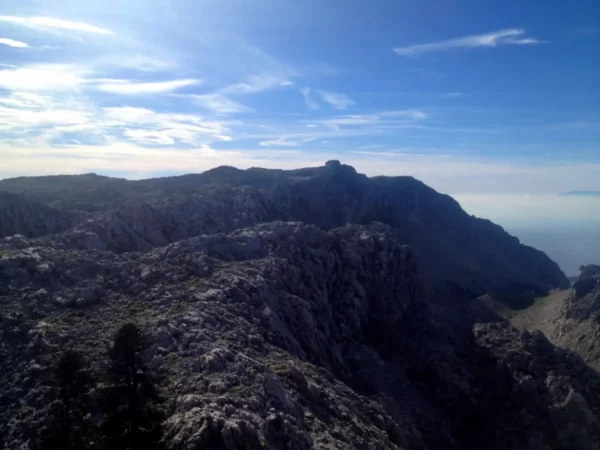 Stunning rocky landscape of Xerovouni with expansive blue skies and distant peaks visible in the background.
