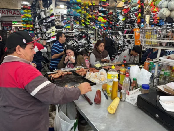 man making Hot dogs amid the dense market 4 in acuncion, paraguay