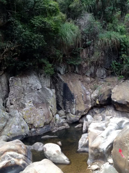 Tranquil Ba Ho Waterfalls showcase smooth rocks and clear water surrounded by lush greenery and steep cliffs.
