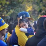 fan of boca juniors holding little daughter on shoulder in buenos aires