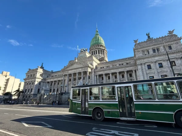 green bus driving through neat central street in downtown buenos aires, argentina
