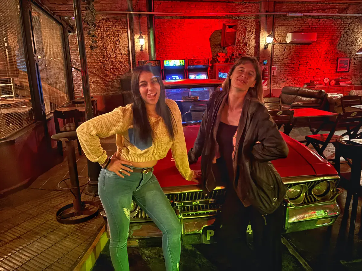 girls posing in front of antique car in a bar in san telmo, buenos aires